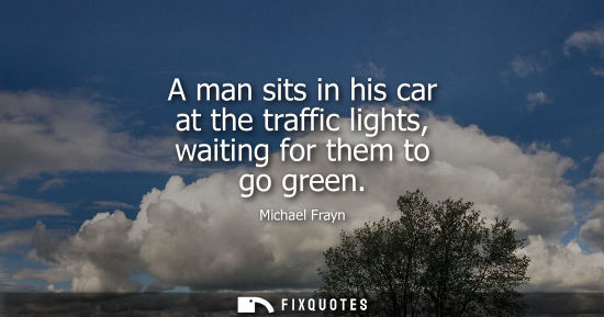 Small: A man sits in his car at the traffic lights, waiting for them to go green